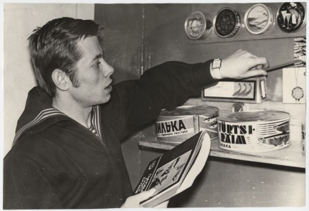 Долгих  Э.  курсант ТМШ ЭРПО Оокеан  у полки с рыбными консервами. 1972 г.