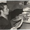 Долгих  Э.  курсант ТМШ ЭРПО Оокеан  у полки с рыбными консервами. 1972 г.